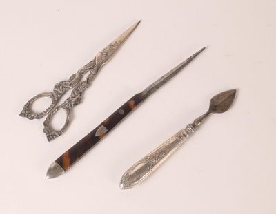 trois types de ciseaux différents et un couteau posés sur une table