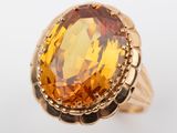 a close up of a gold ring with a large citrine stone