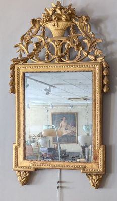 un miroir accroché au mur avec un cadre doré