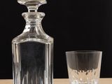 a glass and a decanter sitting on a table