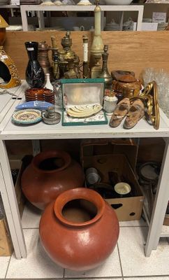 une table sur laquelle sont posés de nombreux vases et autres objets