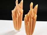 two vases that have folded paper in them on a table