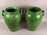 two green vases sitting next to each other on a table