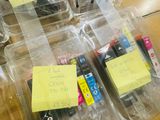 many different colored ink cartridges in plastic containers on a table