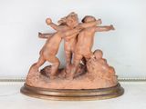 a statue of three children playing with a ball on a table