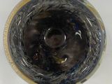 a close up of a glass vase with a black and gold design