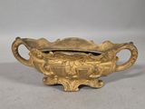 an antique brass bowl with handles and handles on a white surface