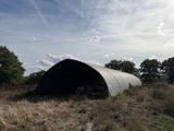 a large metal structure in the middle of a field