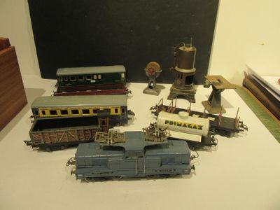 de nombreux petits trains miniatures posés sur une table, avec un tableau noir en arrière-plan