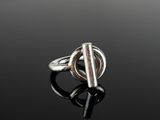 gros plan d'une bague en argent sur une surface noire