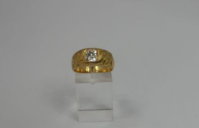 yellow gold ring with a diamond on top of a clear acrylic stand