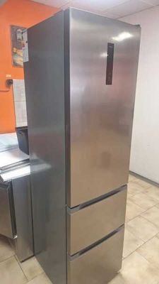 un réfrigérateur en acier inoxydable dans une cuisine aux murs orange