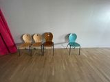three chairs in a row in a room with a red curtain