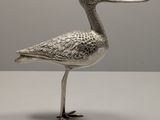 un oiseau en argent au long bec, posé sur une table