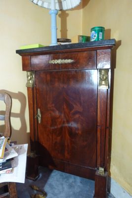 a small table with a lamp on top of it next to a chair