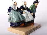 a figurine of two people riding a motorcycle