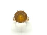 a close up of a ring with an orange stone on it