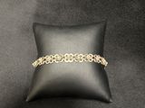 a black pillow with a gold chain bracelet on it