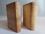 two old books that are sitting on a table