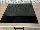une plaque de cuisson noire surmontée d'un brûleur noir