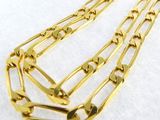 gros plan d'un collier à chaîne en or sur une surface blanche