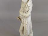 an old statue of a man with a hat and a cane