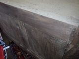 a wooden chest with a wooden top and a red rug