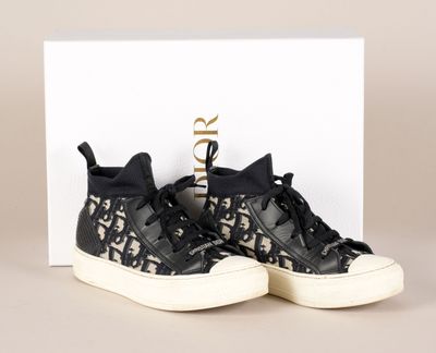 une paire de baskets noires et blanches posée sur une boîte blanche