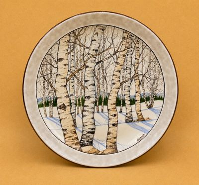 une assiette sur laquelle est représenté un motif de bouleaux