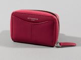 the pink leather wallet is open and has a zipper on the front