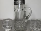 three glasses and a pitcher sitting on a table