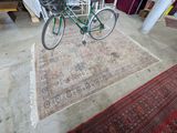 a bicycle that is parked on a rug in a room