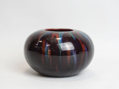 a black and red vase sitting on a white surface