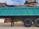 a green dump truck parked in front of a building