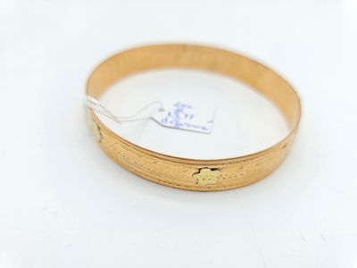 une image d'un gros plan d'une bague en or sur une surface blanche