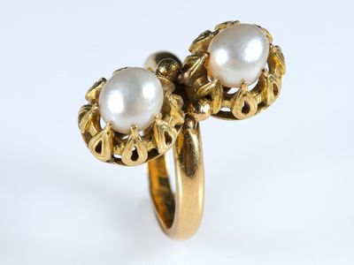 une image représentant une bague en or surmontée de deux perles