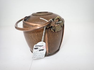 un sac en papier brun muni d'une étiquette, posé sur une surface blanche