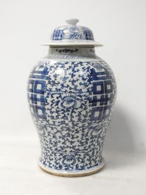 un vase bleu et blanc avec un couvercle posé sur une table