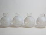 four white glass vases sitting next to each other on a white surface