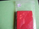 a piece of red soap sitting on top of a piece of green paper