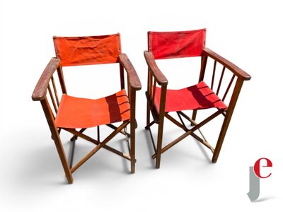 two red chairs sitting next to each other on a white surface