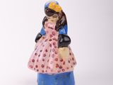 a small figurine of a woman in a pink dress