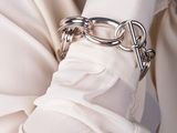 a woman wearing a white shirt and a silver chain bracelet
