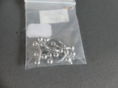 a bag of silver beads and a pair of scissors on a table