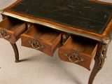 a small desk with three drawers and a marble top