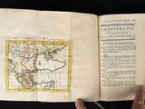 someone is holding an open book with a map on it