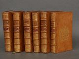 quatre vieux livres sont alignés les uns à côté des autres sur une surface grise