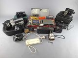 a lot of cameras and other electronic equipment on a table