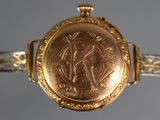 an image of a close up of a gold watch with a horse on it
