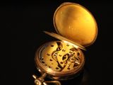 an old pocket watch sitting on top of a black table